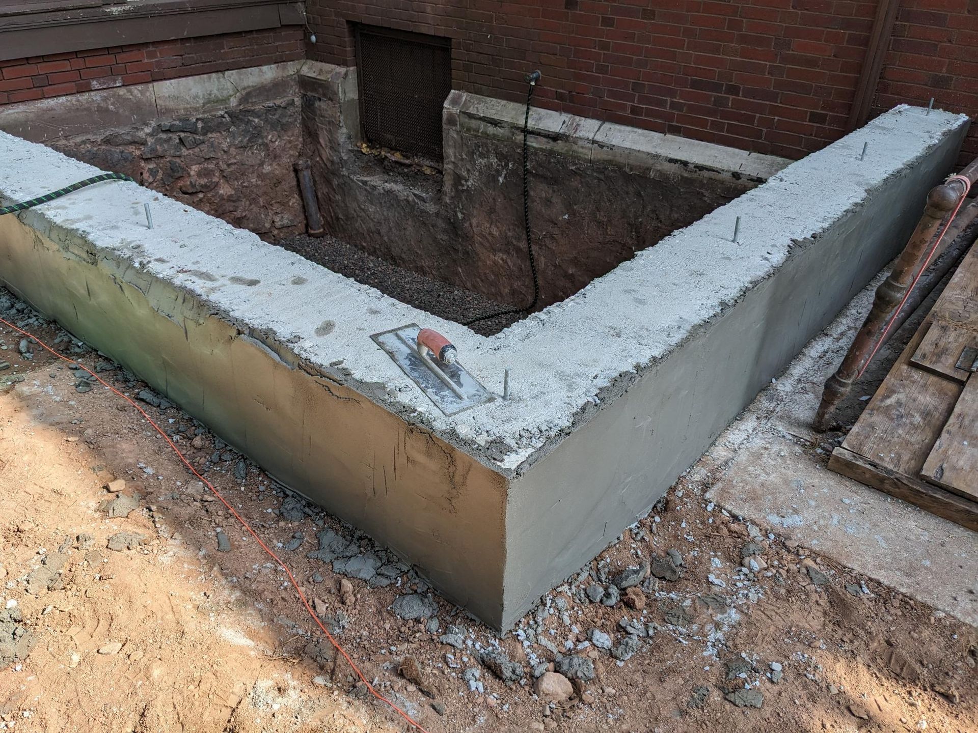 A concrete wall is being built next to a brick wall.