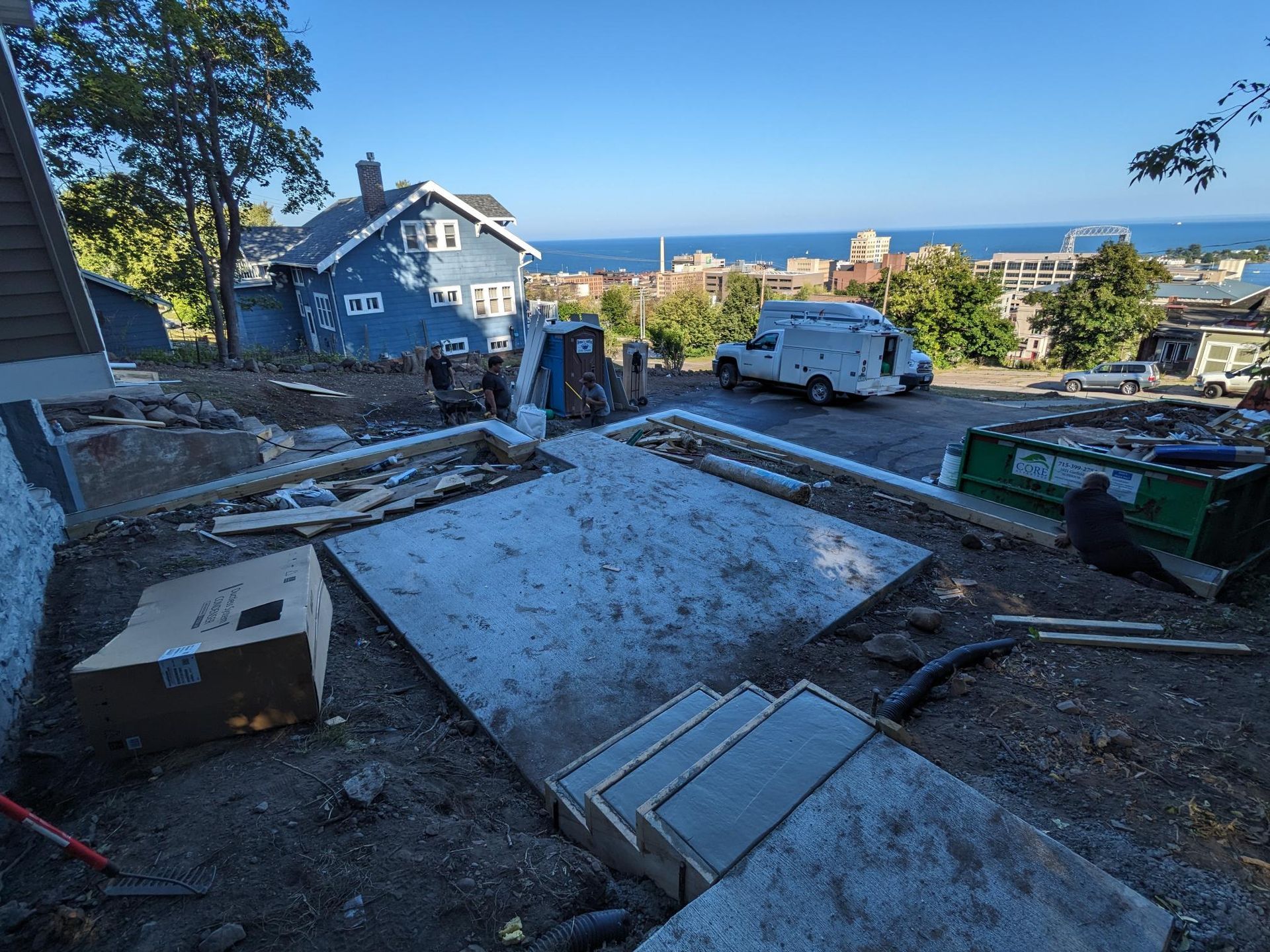 A construction site with a blue house in the background.