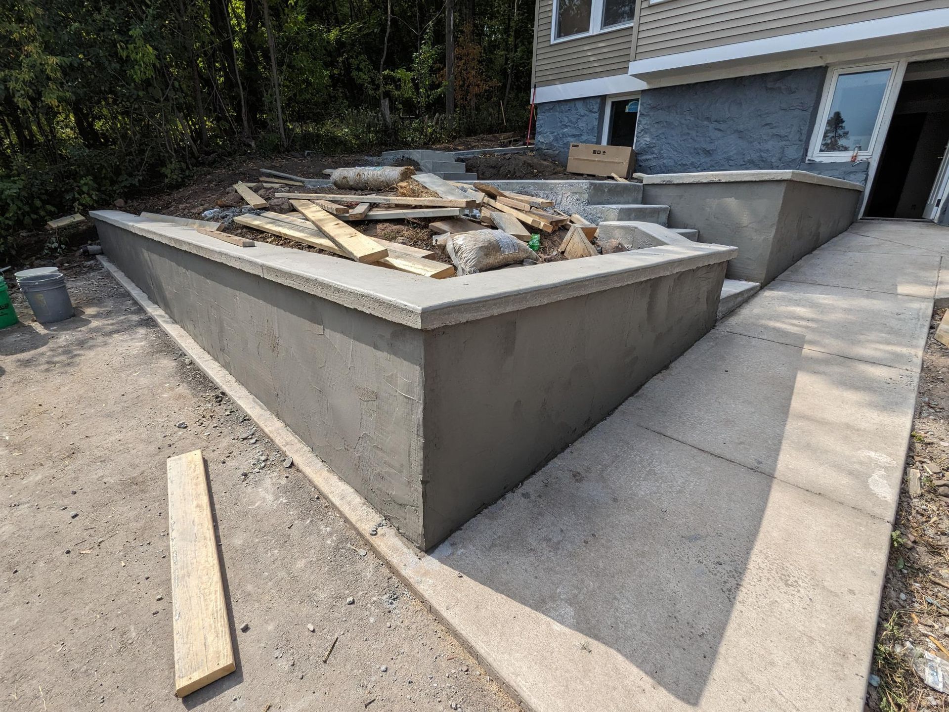 A concrete wall is being built in front of a house.