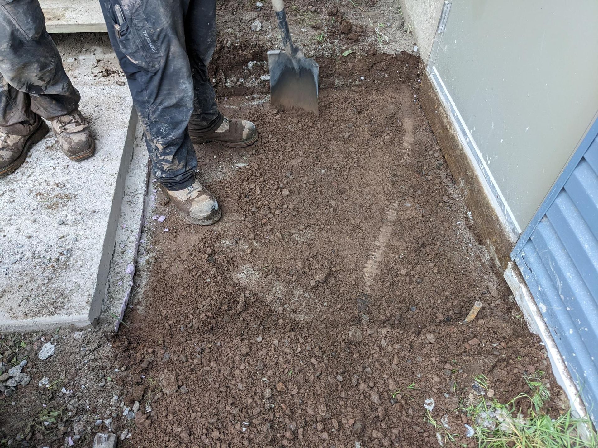 A person is digging in the dirt with a shovel.