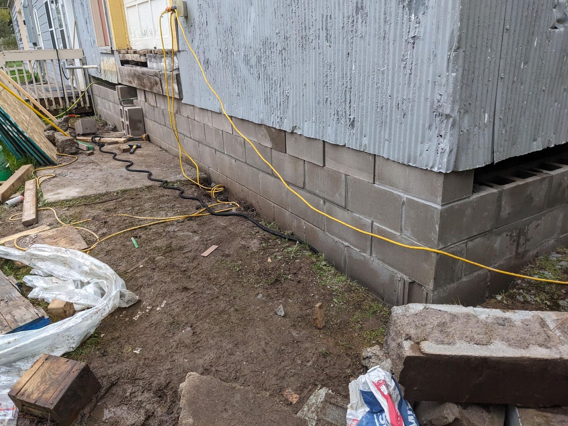 A yellow power cord is connected to the side of a building.