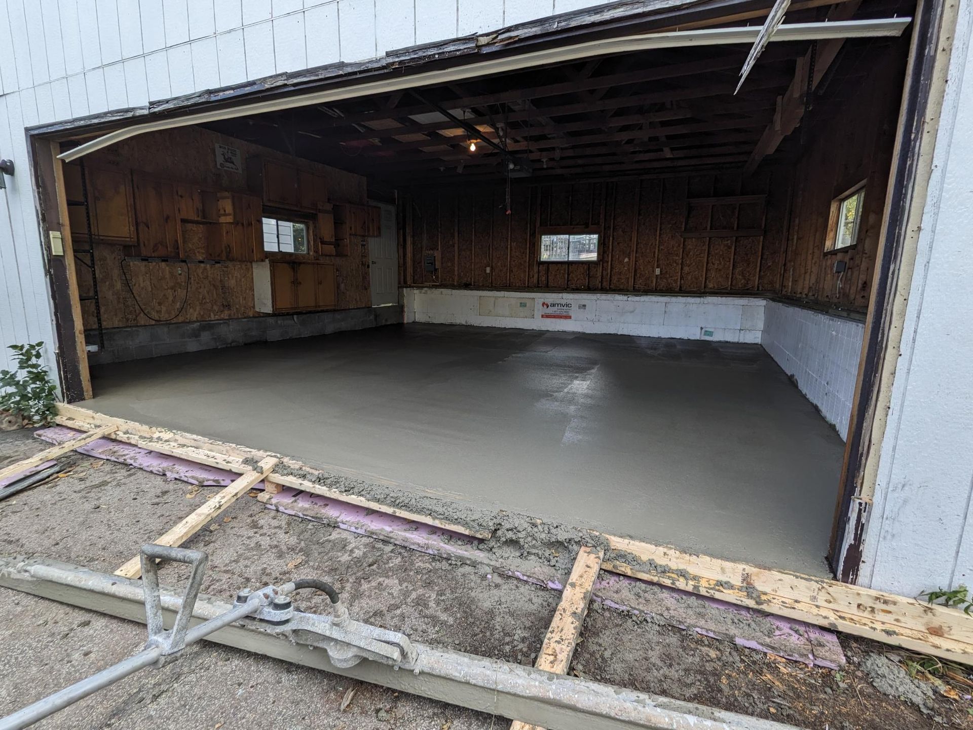 A garage with the door open and a concrete floor.