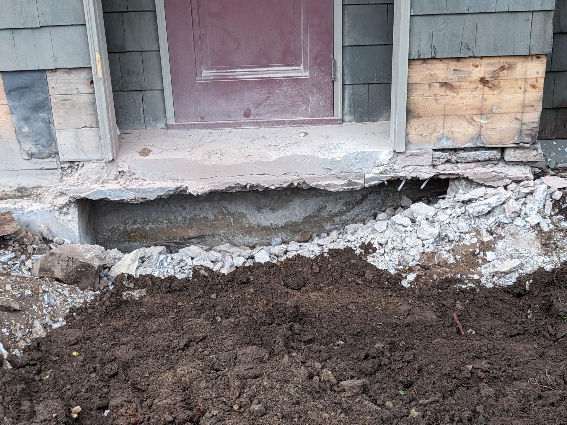 A house with a hole in the ground in front of it.