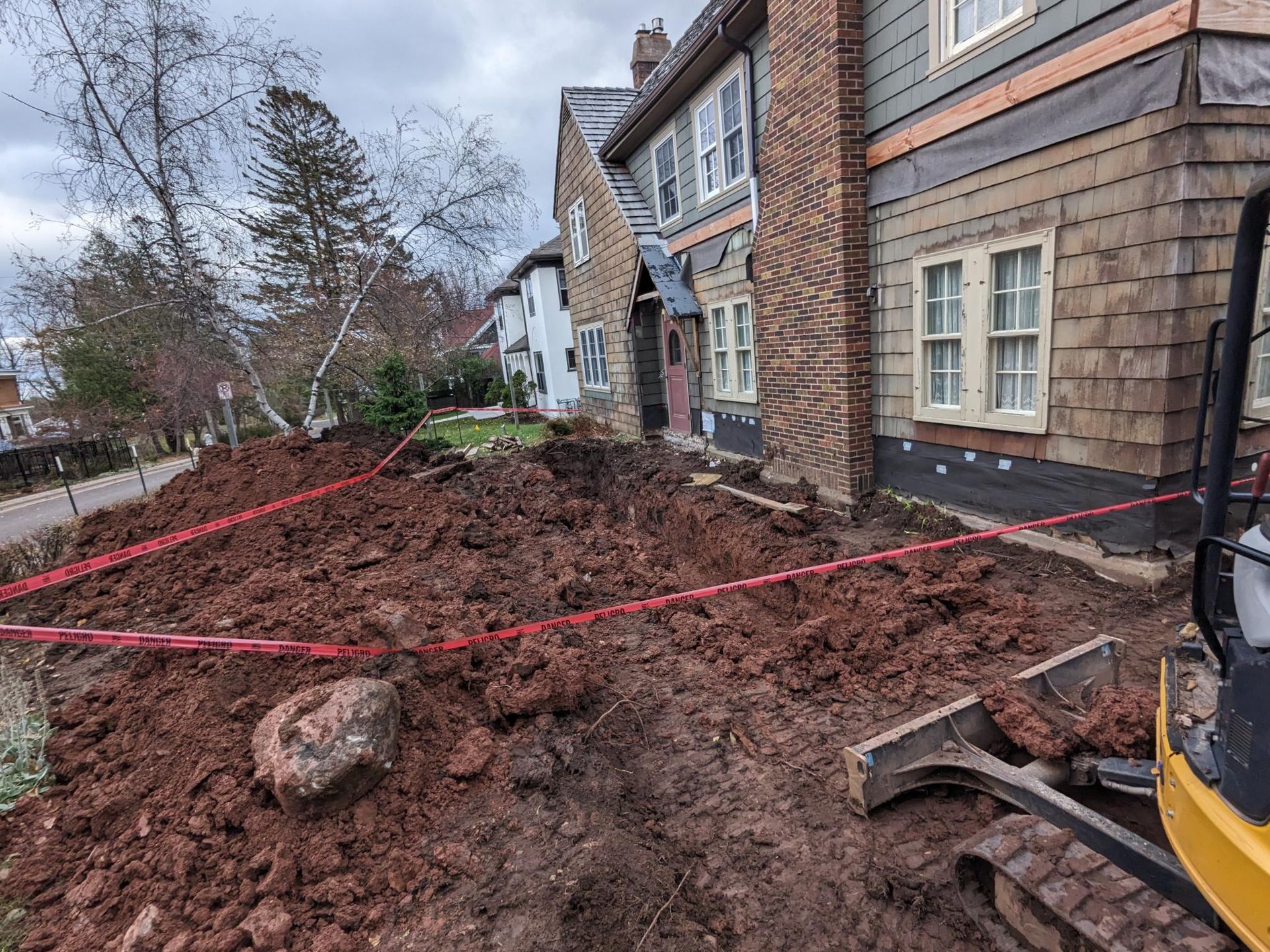 A large pile of dirt is in front of a house.