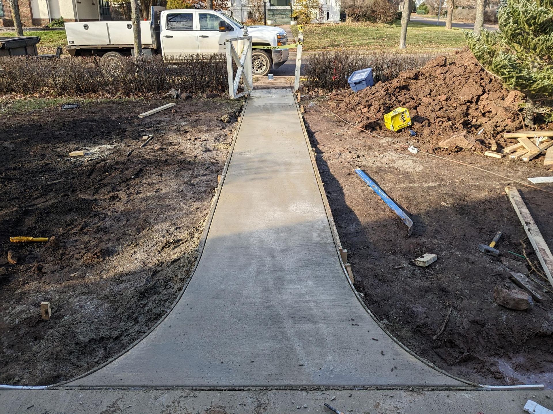 A concrete walkway is being built in a yard.