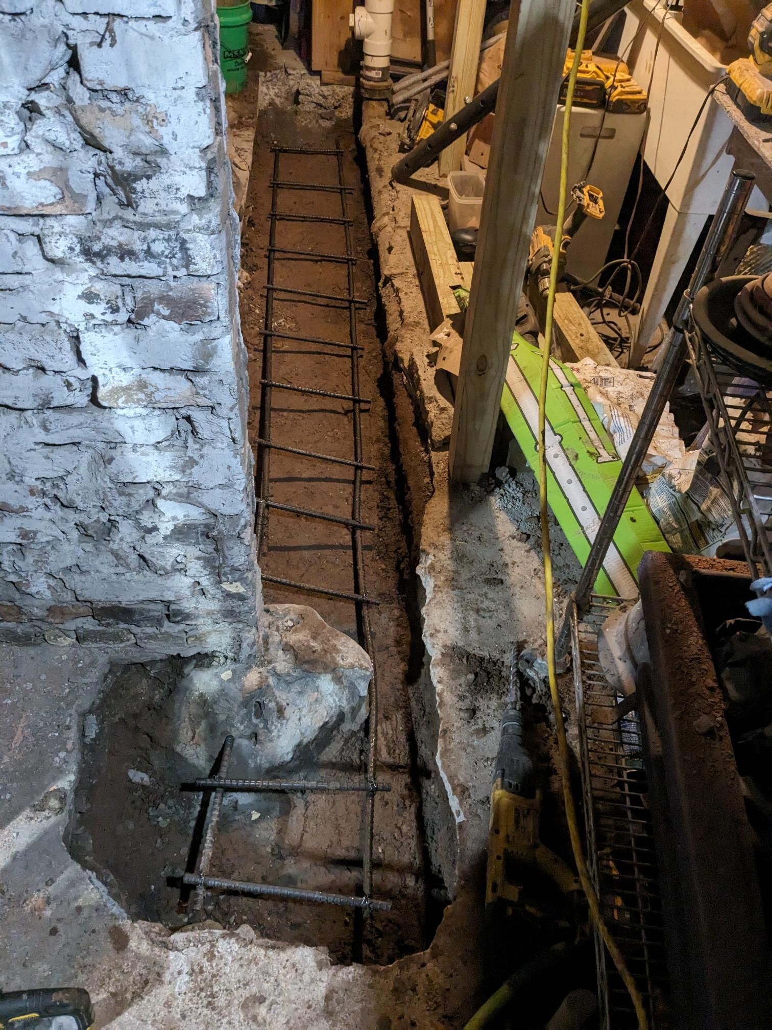 A brick wall is being built in a basement.