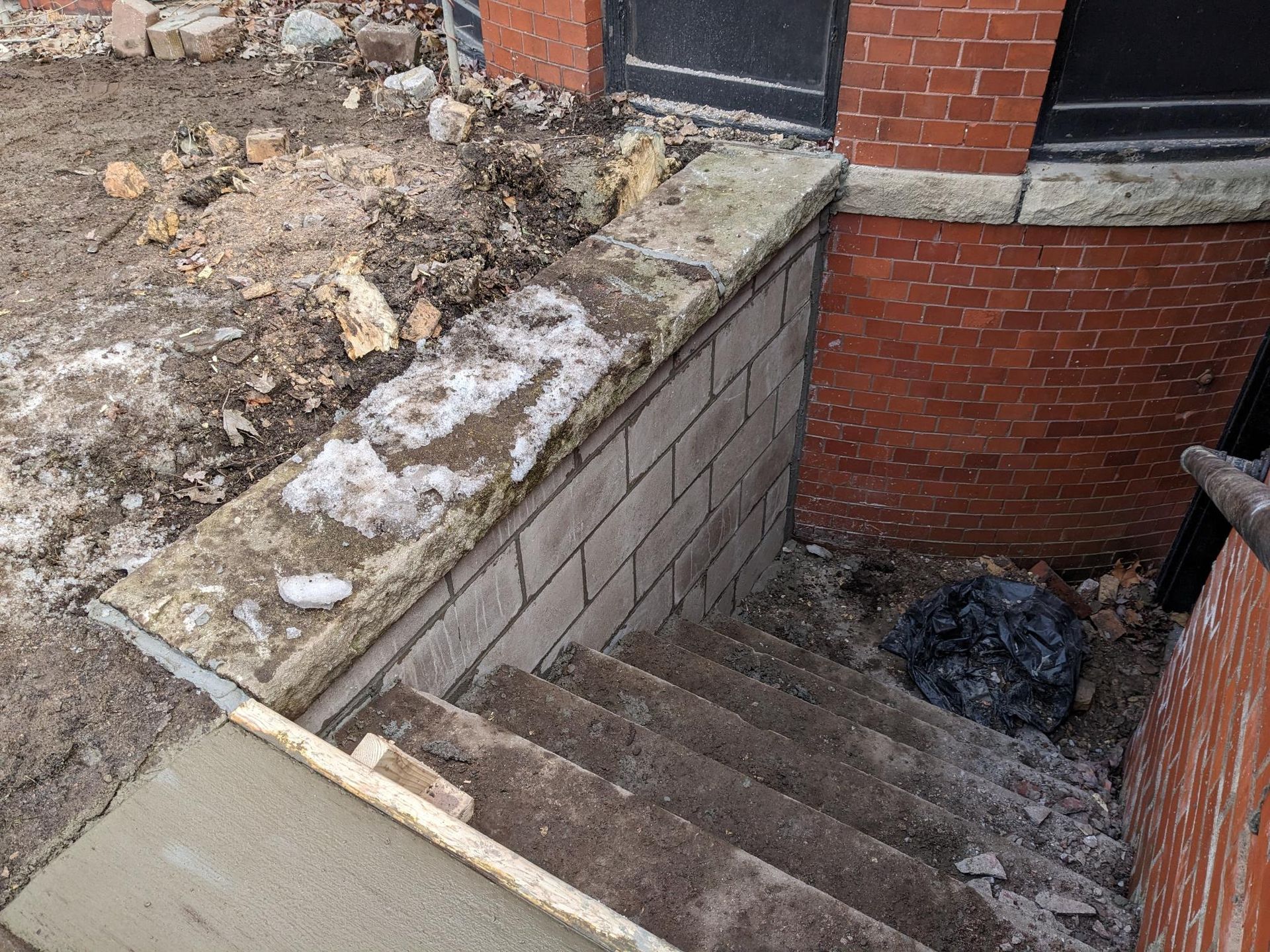 A set of stairs leading up to a basement under a brick building.