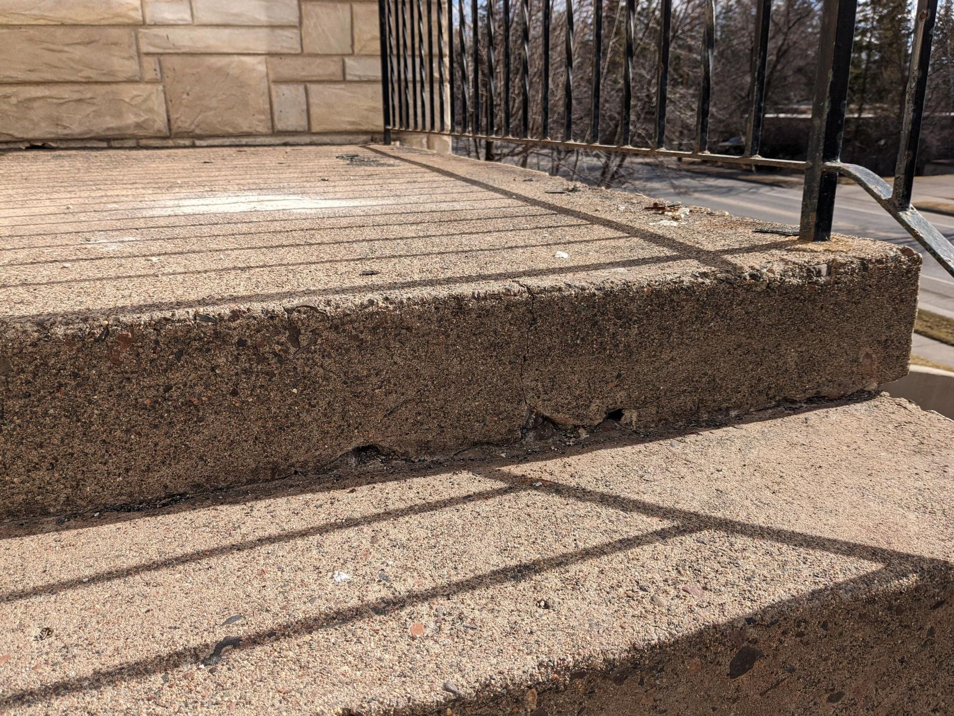 A close up of a set of concrete steps leading up to a balcony.
