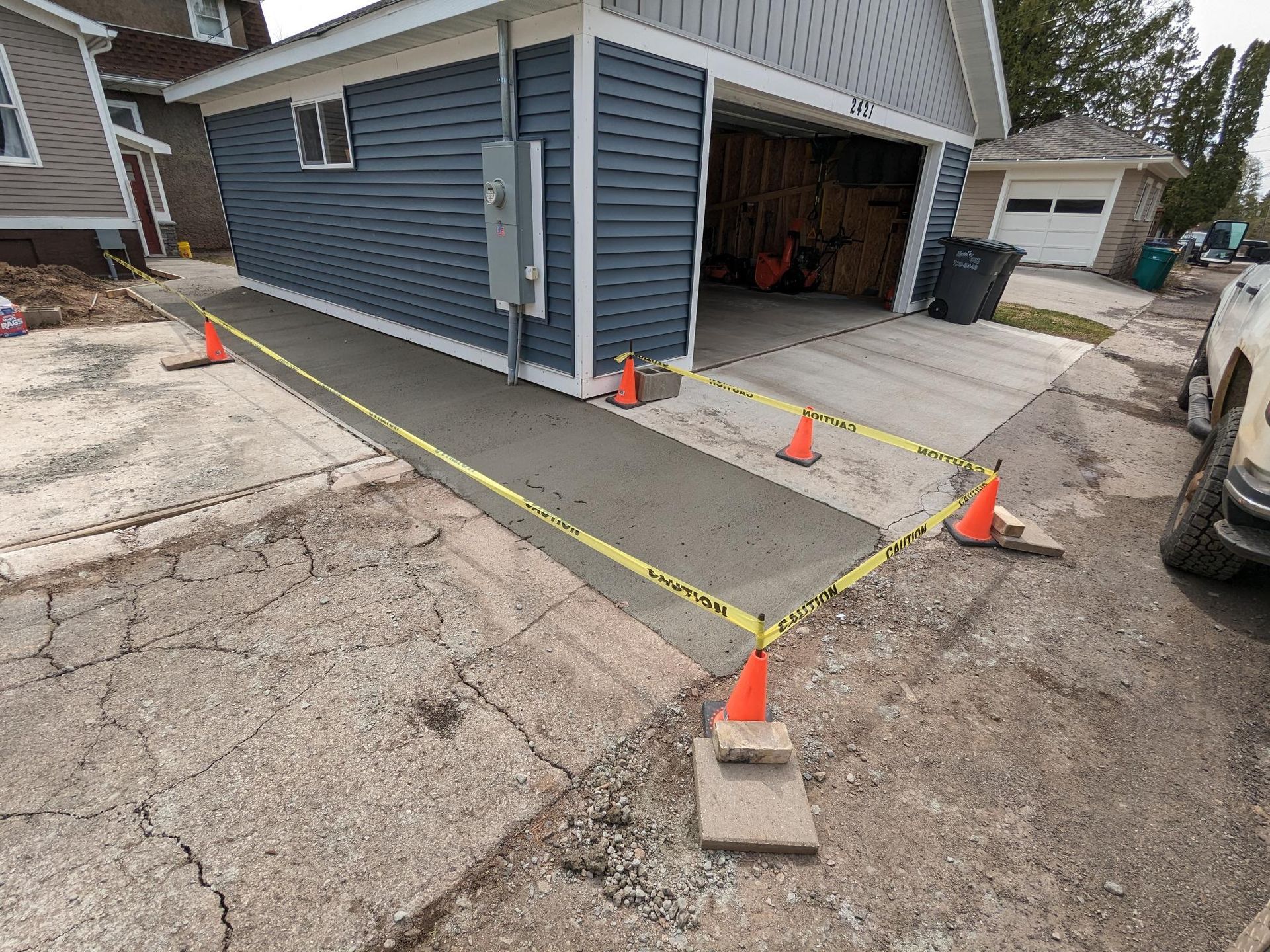 A concrete ramp is being built in front of a garage.