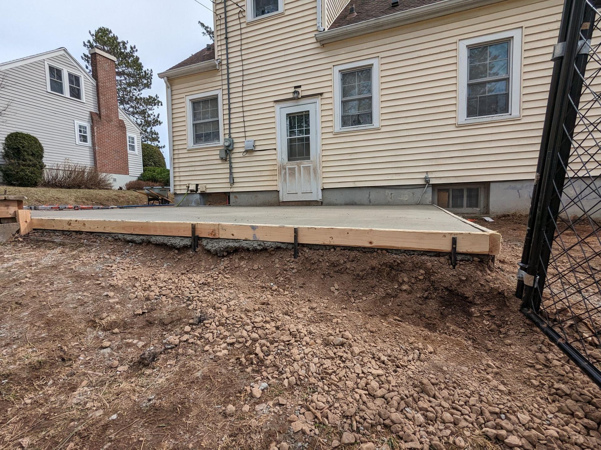 A concrete slab is being built in front of a house.