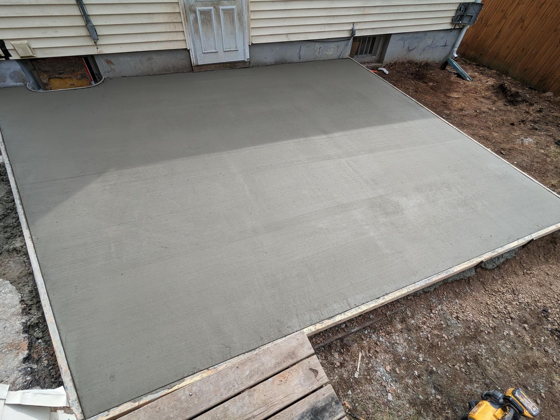 A concrete floor is being built in front of a house.