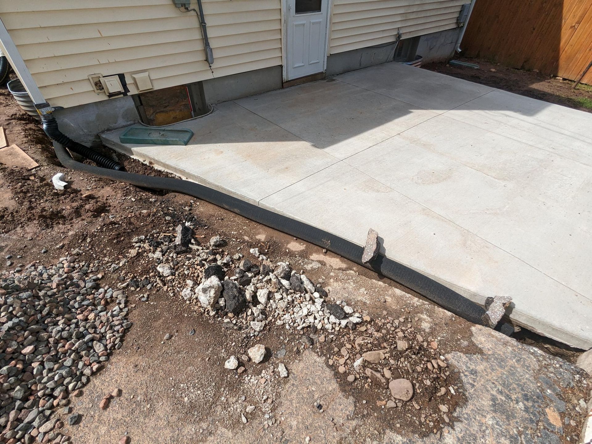 A concrete patio is being built in front of a house.