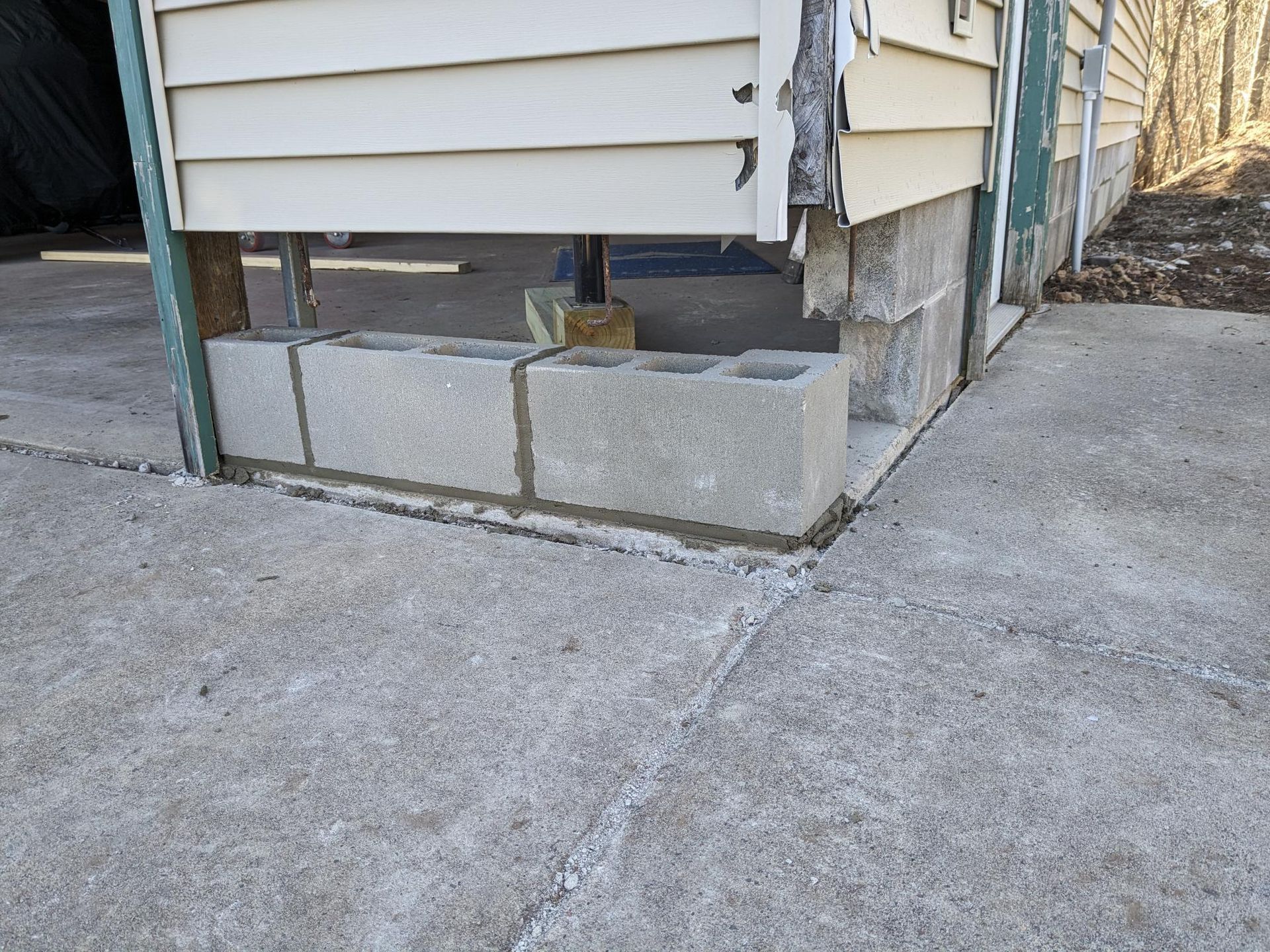 A corner of a house with concrete blocks in front of it