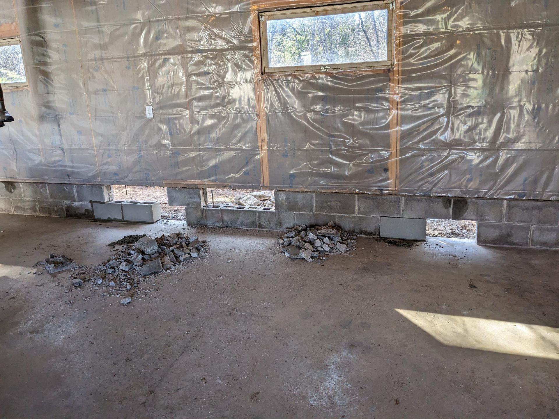 A room with a lot of rocks on the floor and a window