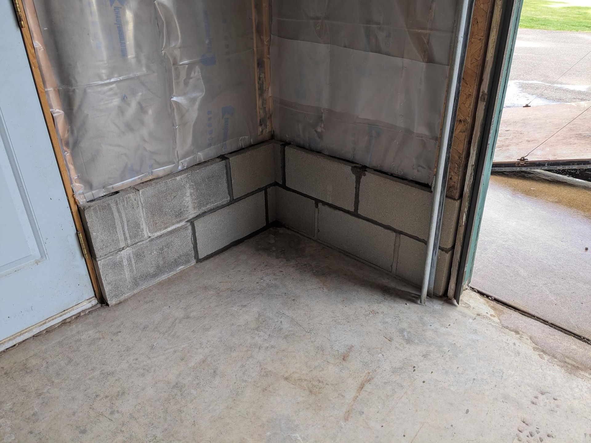 A corner of a building with bricks and a door.