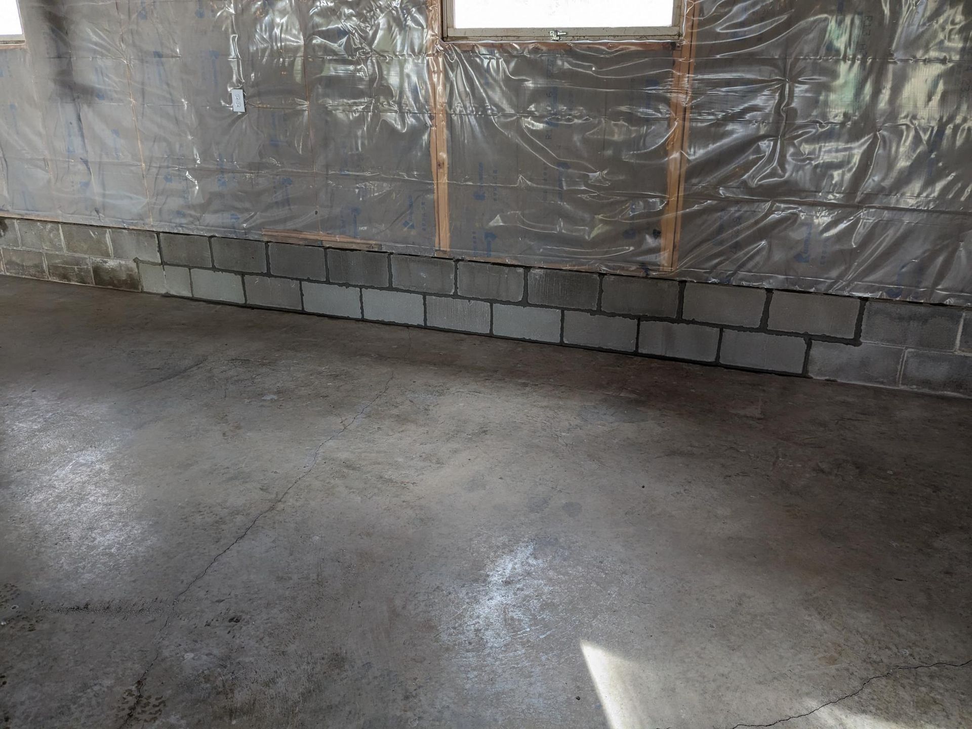 A room with a brick wall and a concrete floor.