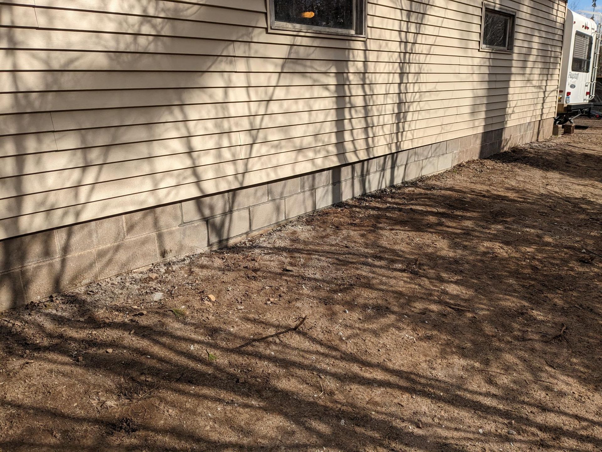 A house with a lot of dirt on the ground in front of it.