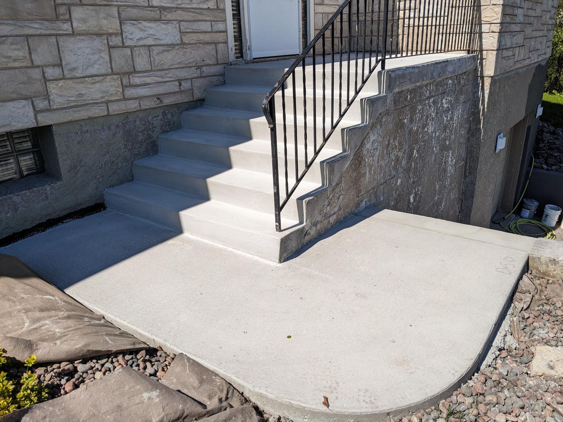 A set of stairs leading up to a house with a metal railing.