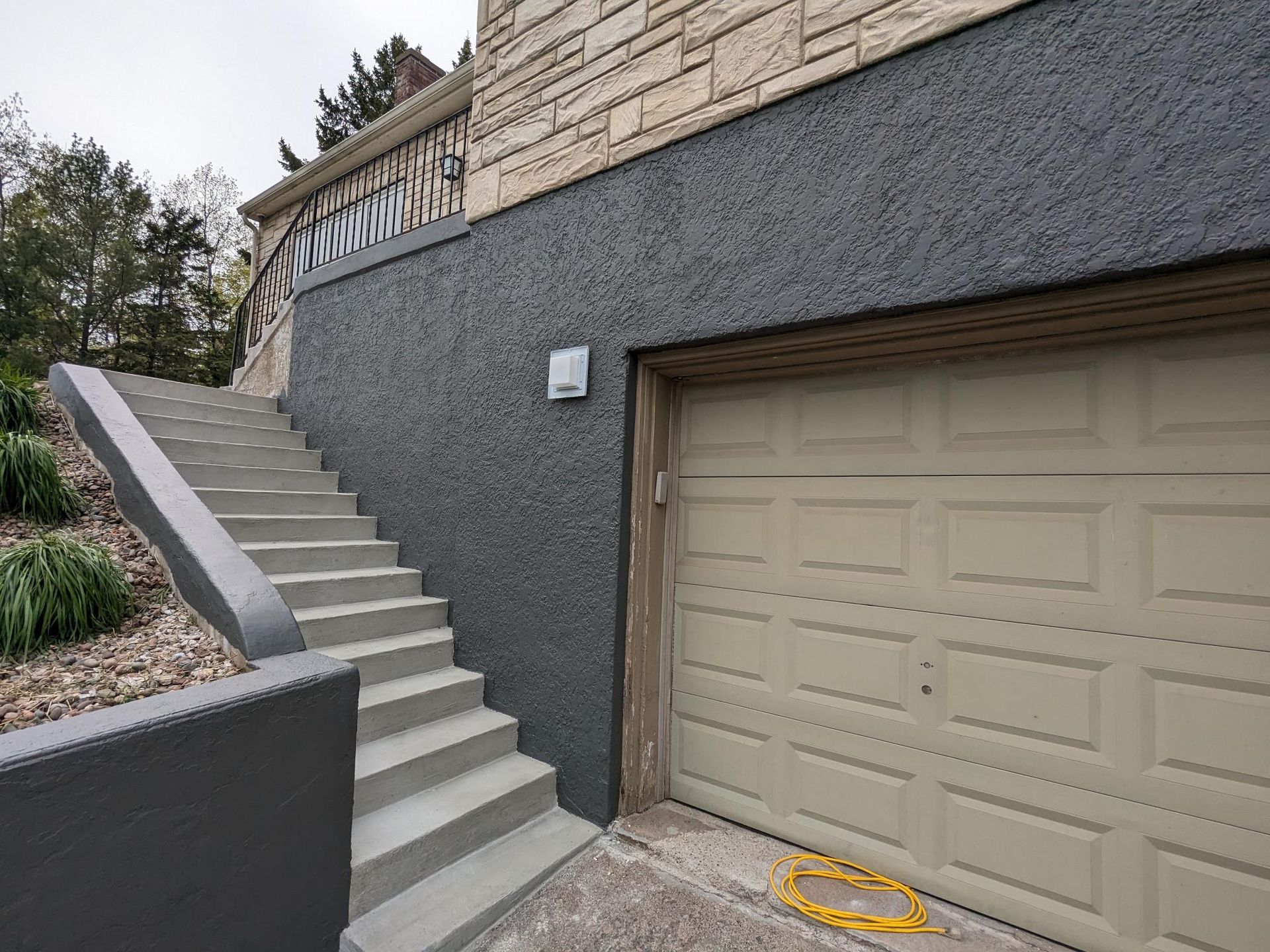 There are stairs leading up to a garage door.