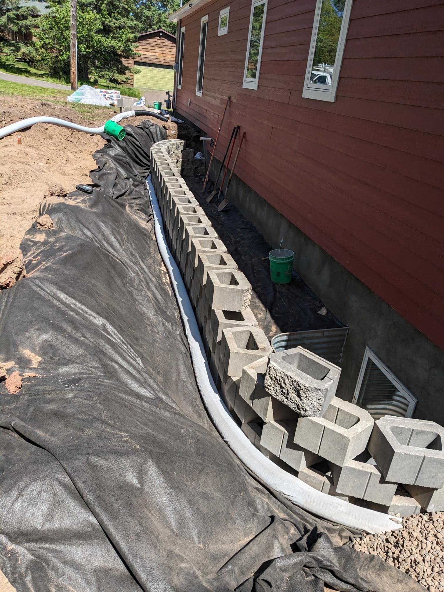A drainage system is being installed on the side of a house.