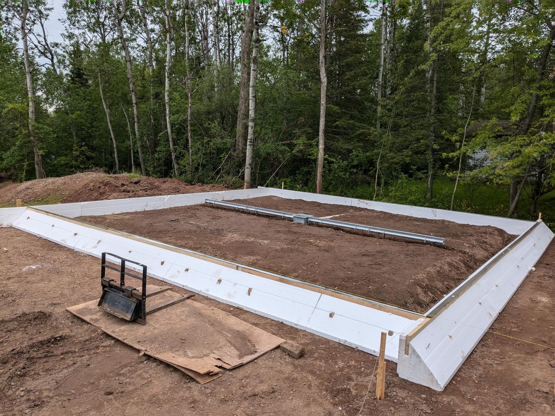 A foundation for a house is being built in the middle of a forest.