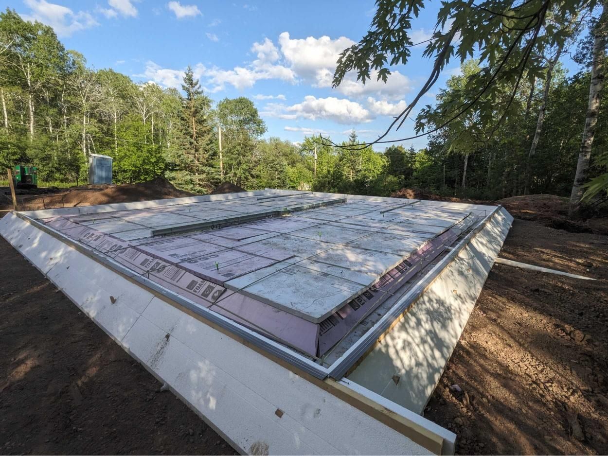 A foundation for a house is being built in the woods.