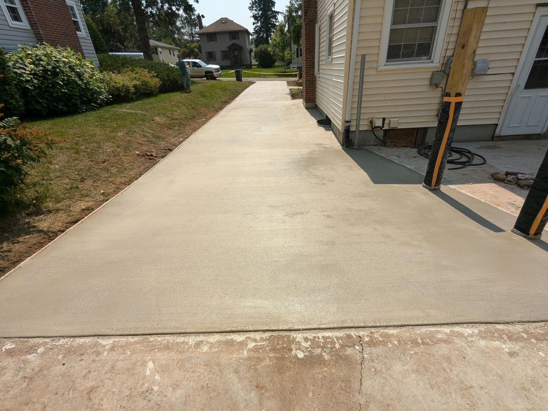 A concrete driveway is being built in front of a house.