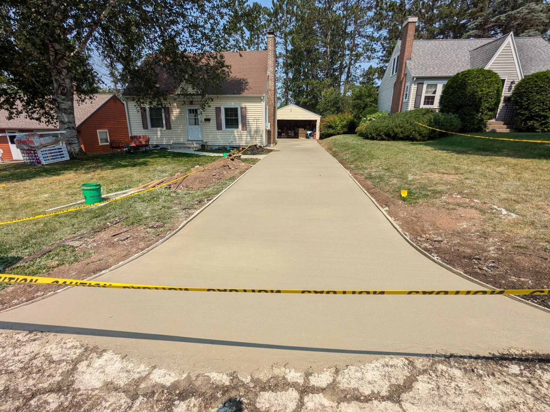 A concrete driveway is being built in front of a house.