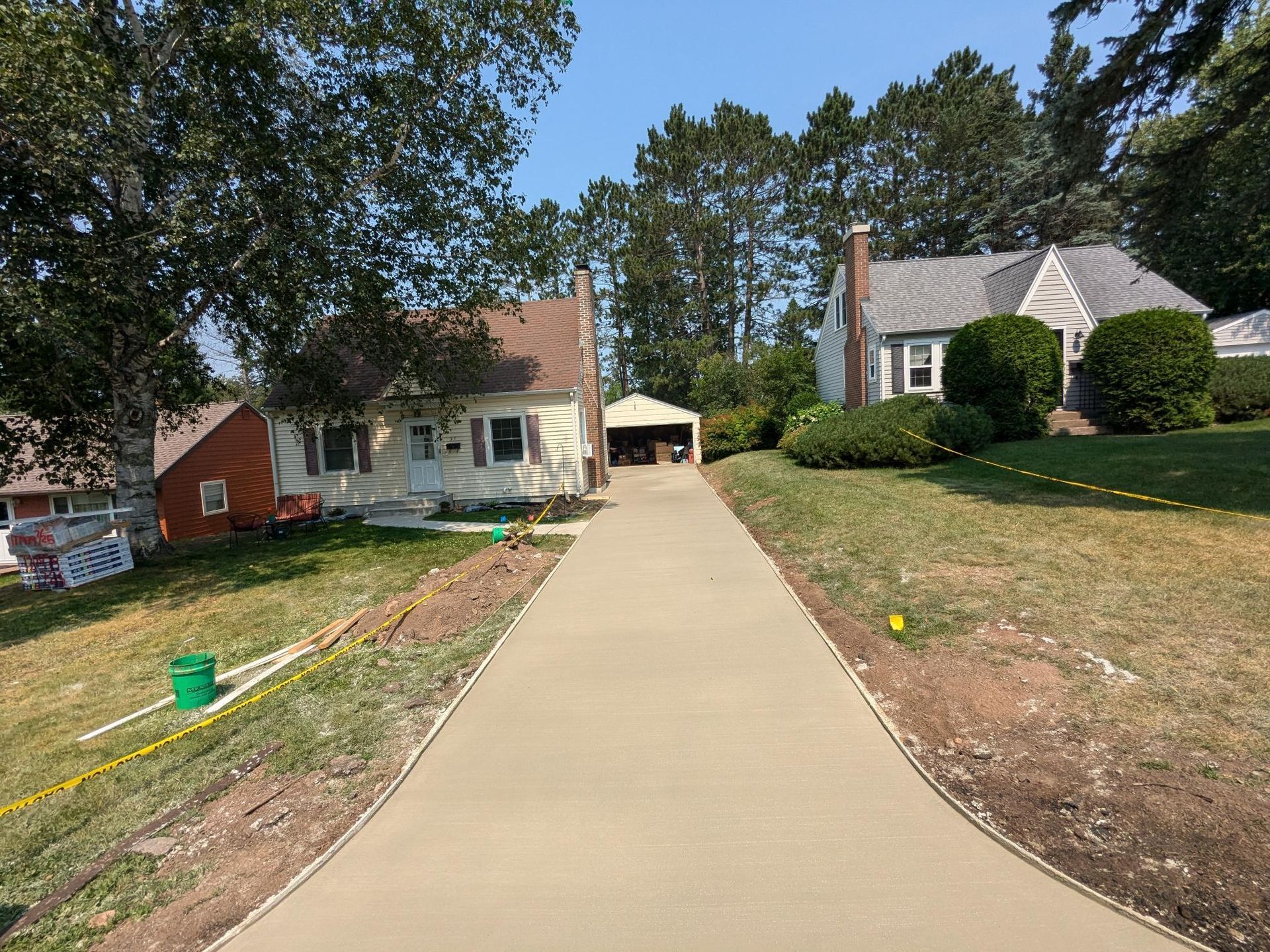 There is a concrete driveway leading to a house.