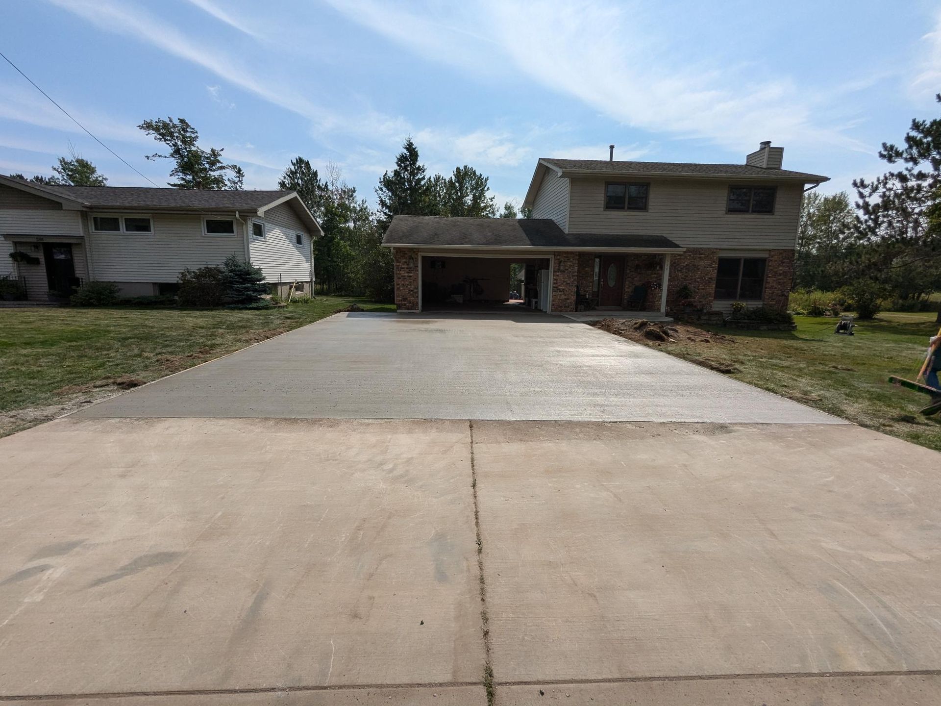 A concrete driveway leading to a house with a garage