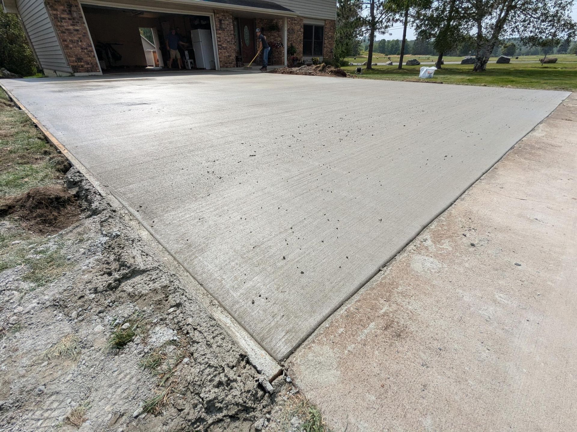 A concrete driveway is being built in front of a house.