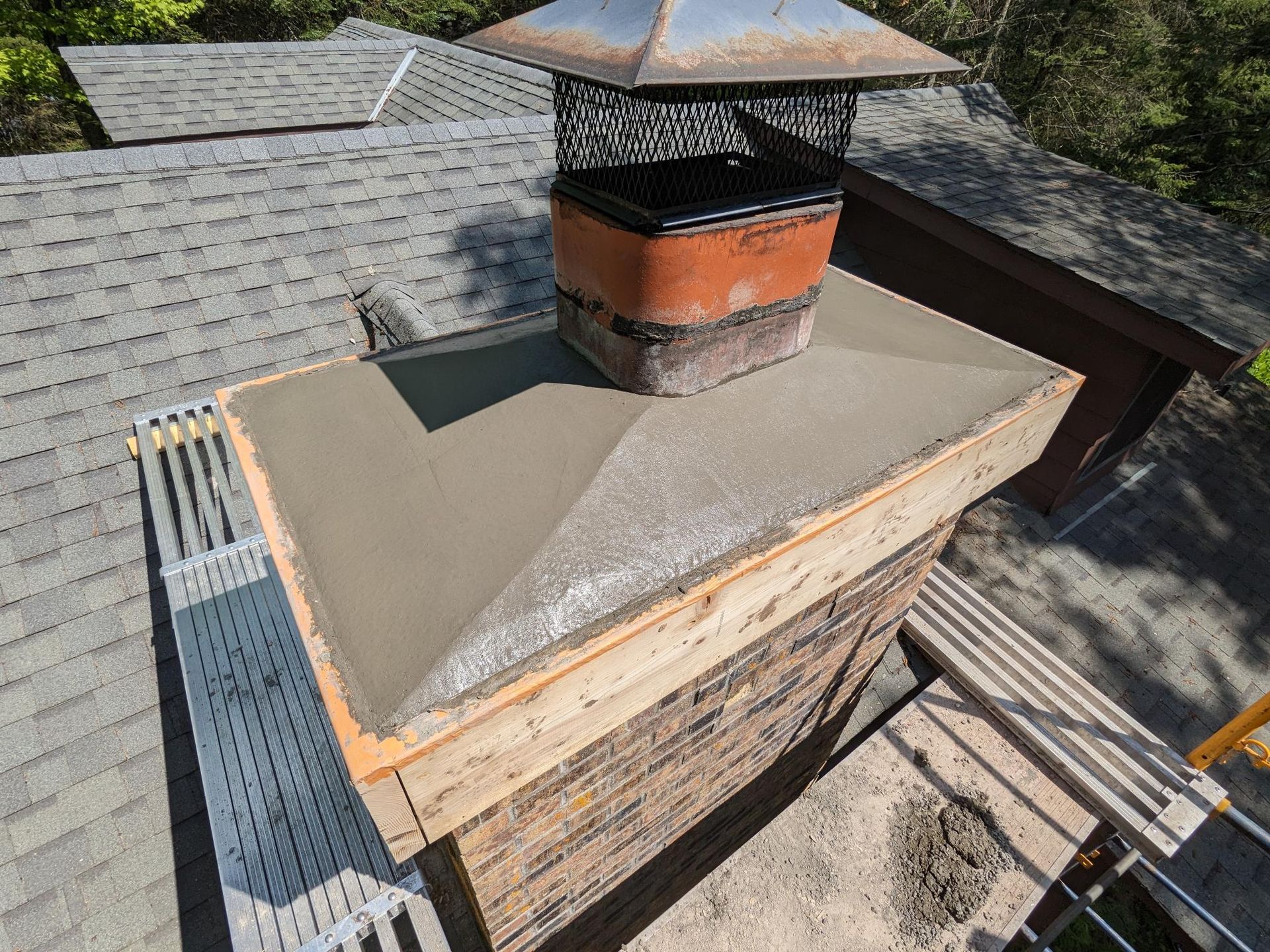 A chimney is being built on top of a roof.