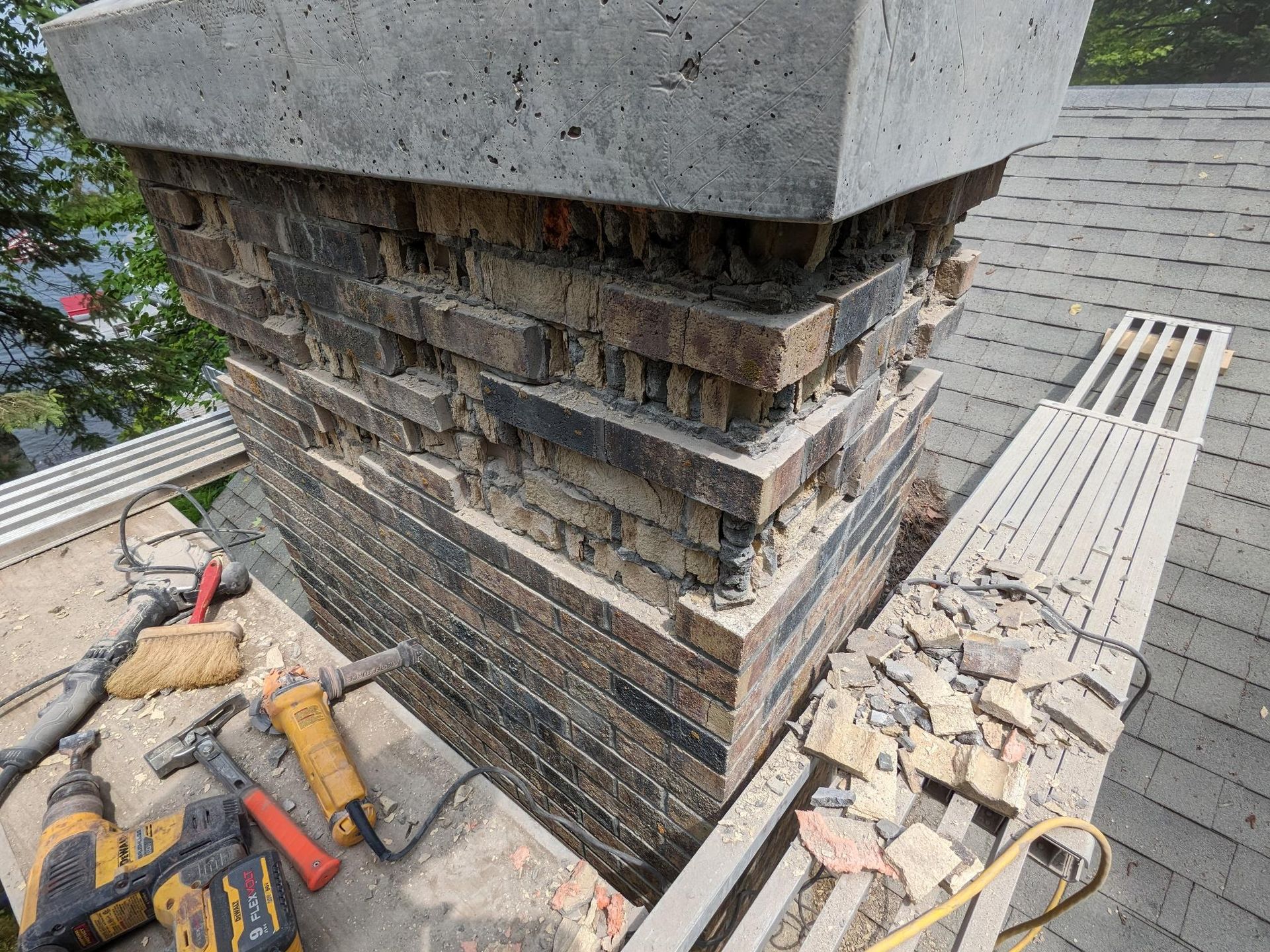 A chimney is being repaired on the roof of a house.
