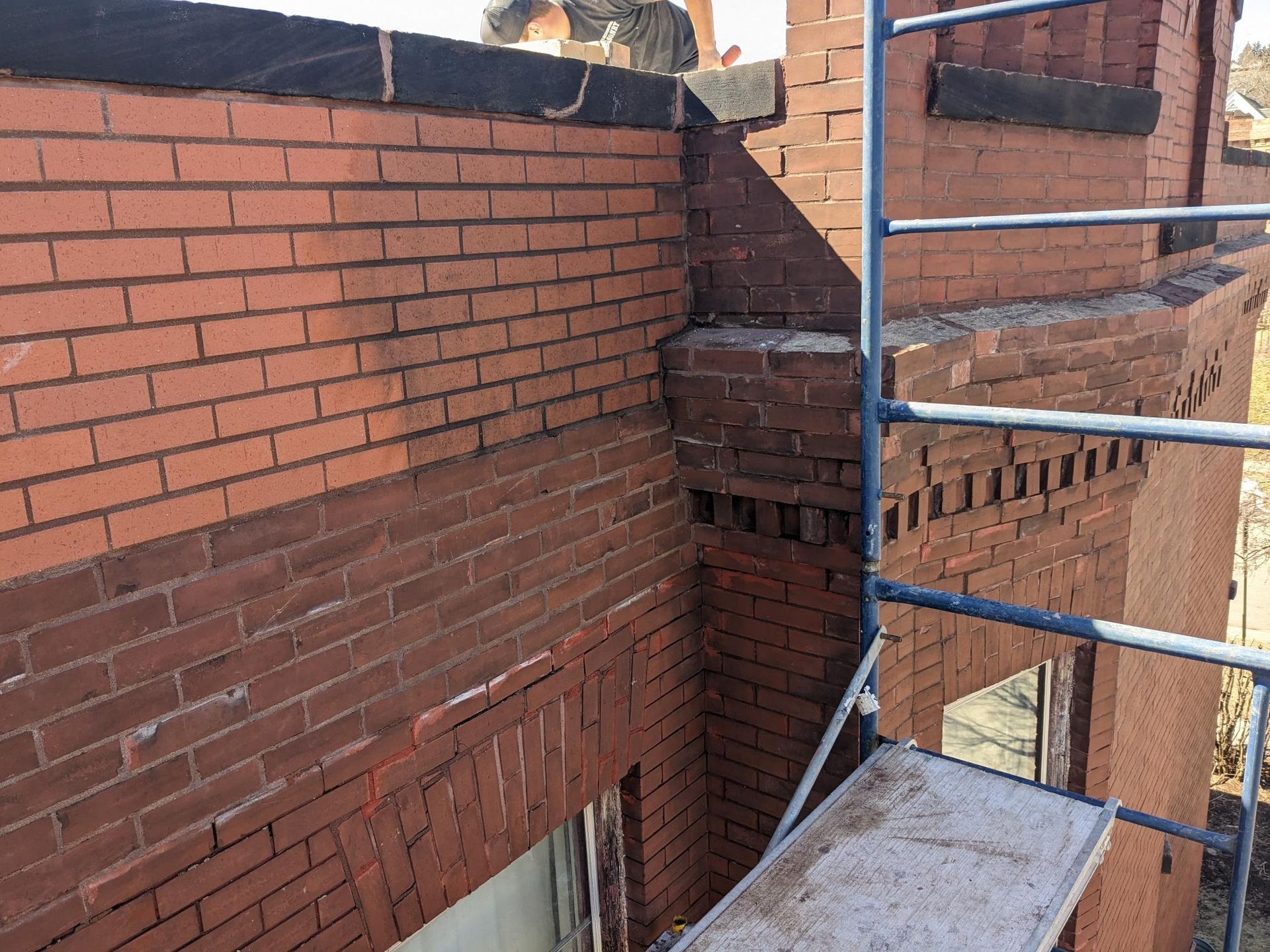 A brick wall with a scaffolding attached to it.