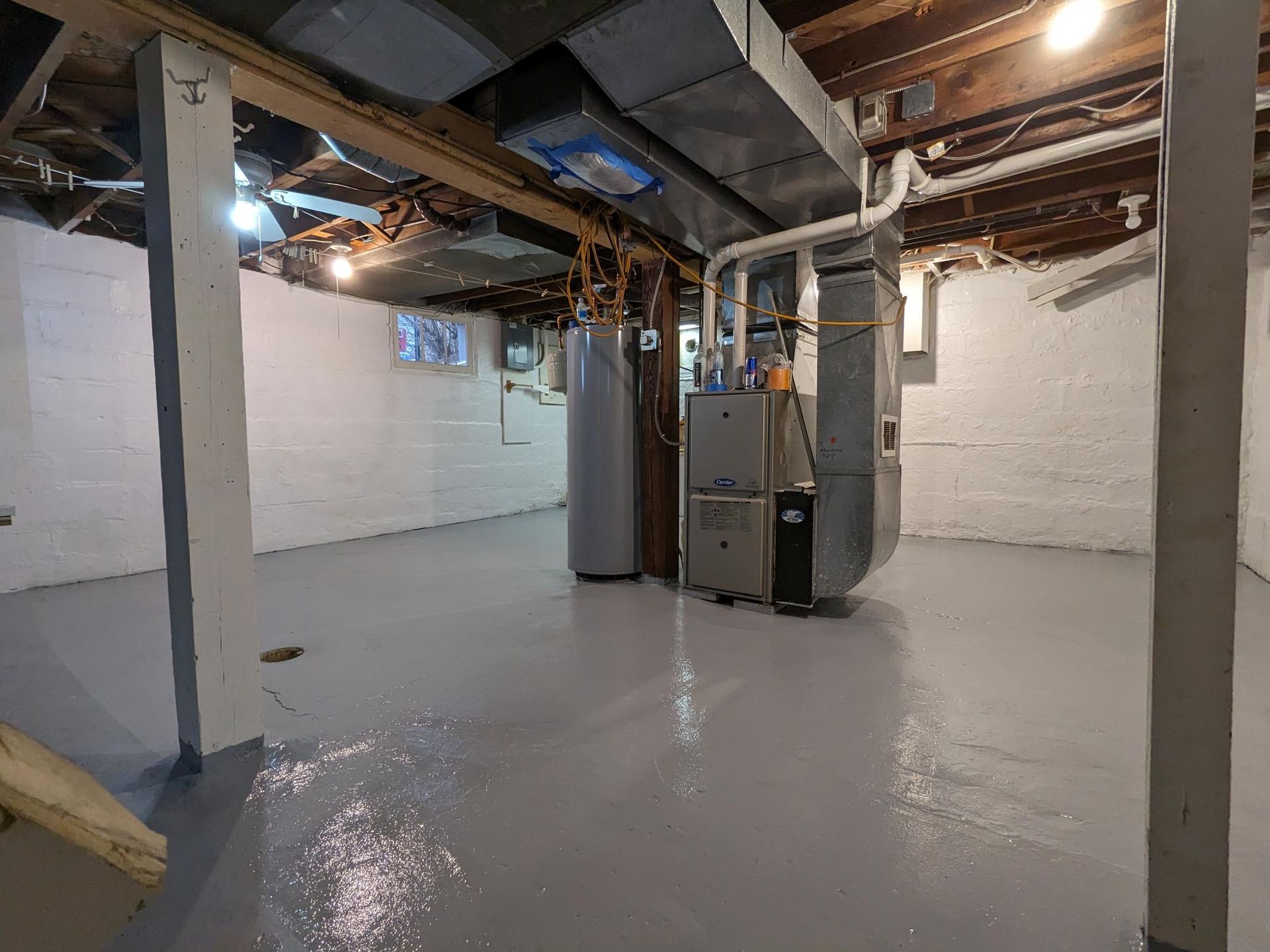 An empty basement with a furnace and a water heater.