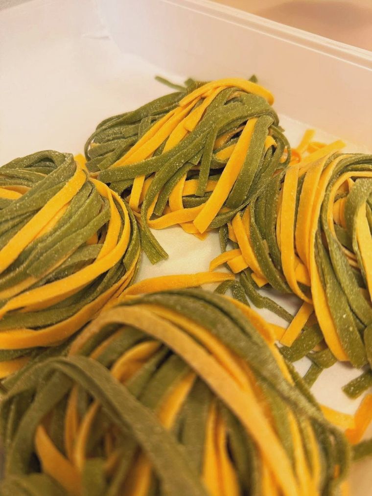 Passaggio coperto all'aperto di notte, con lanterne illuminate e un edificio in pietra scura.