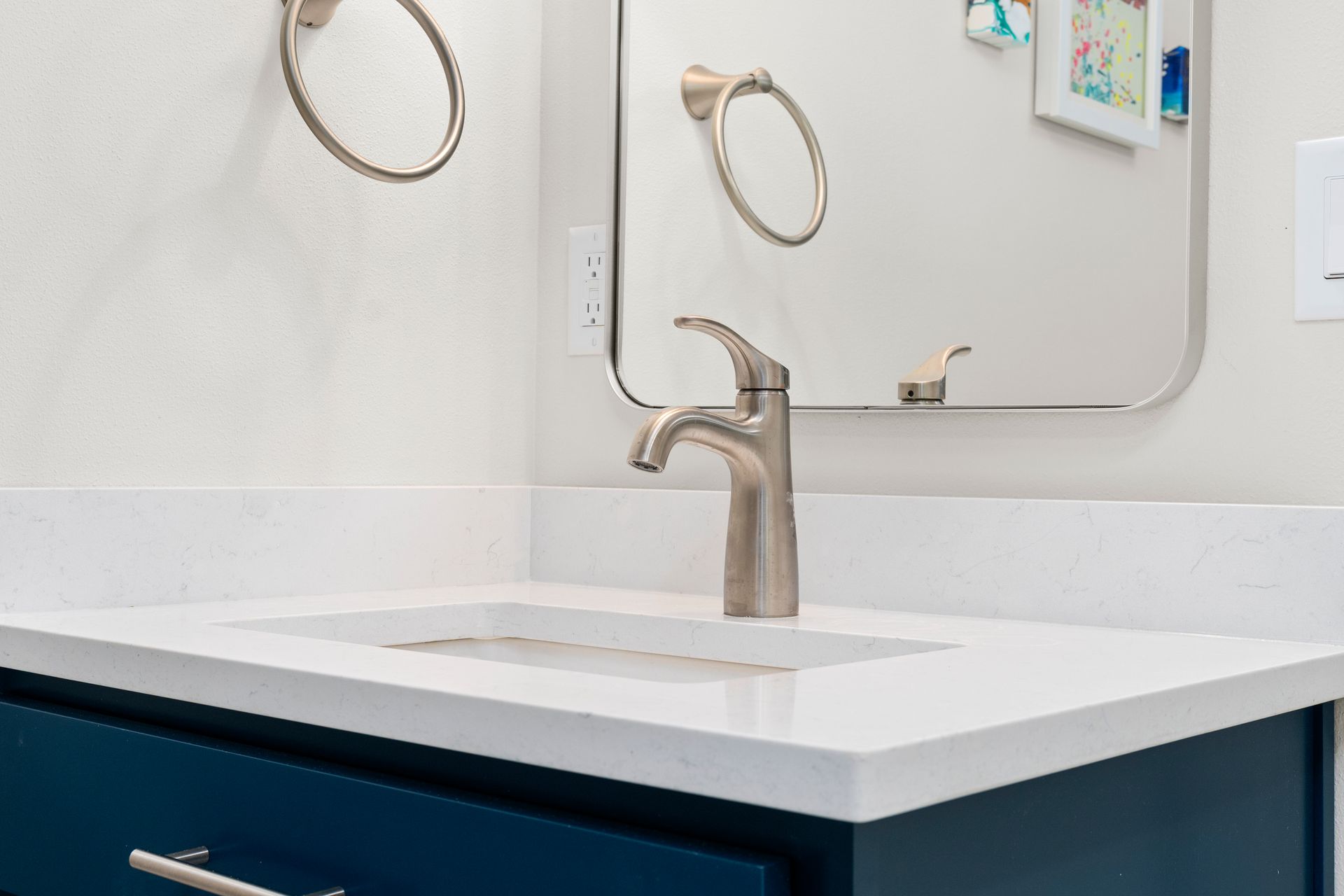 white sink, blue vanity and chrome faucet