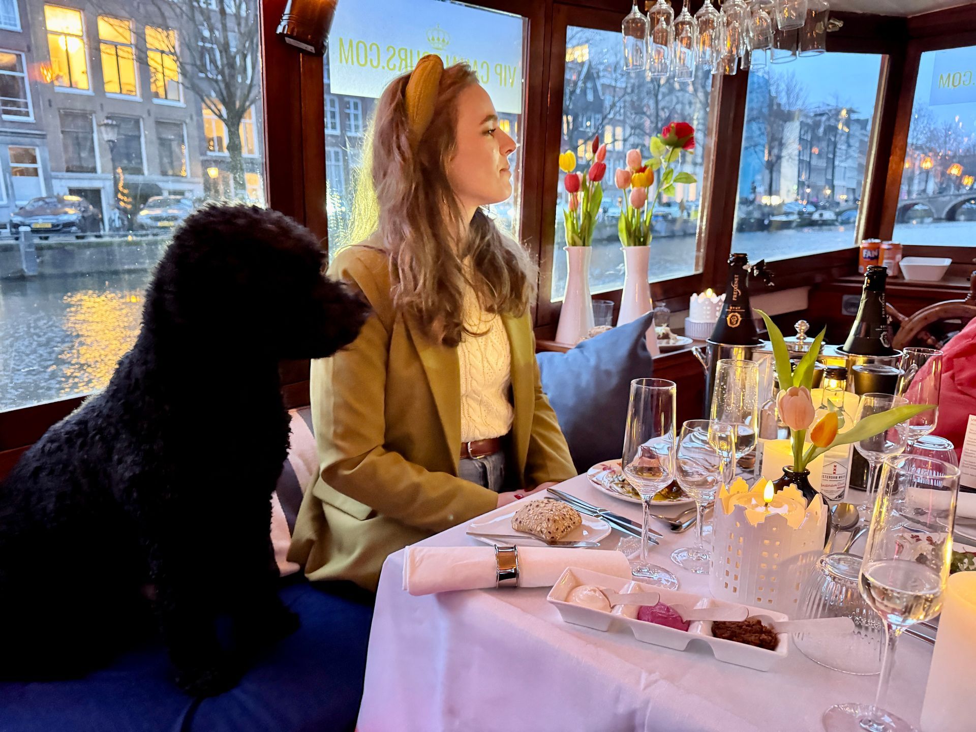 View from a boat's helm, showcasing interior with wood paneling and canal view.