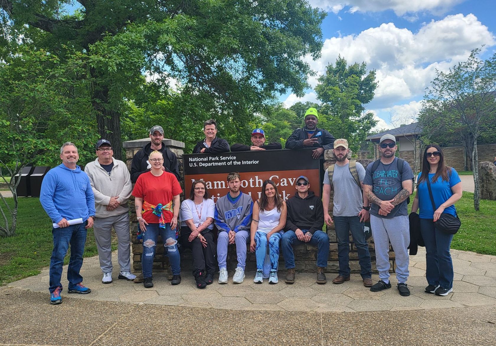 A group of people are posing for a picture in front of a sign.