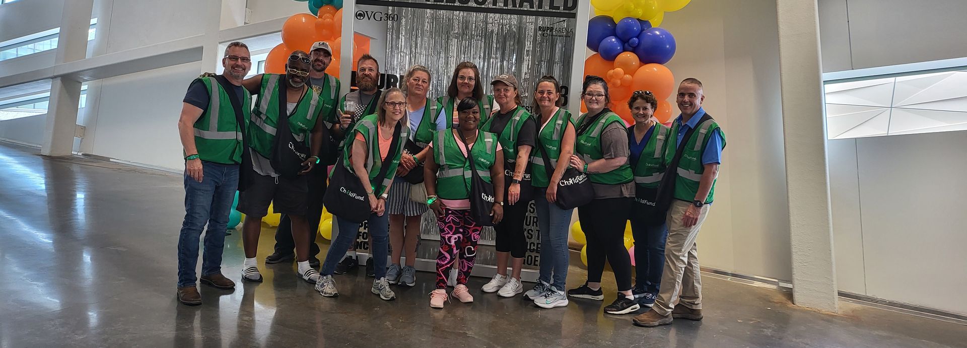 A group of people are posing for a picture in a room with balloons.