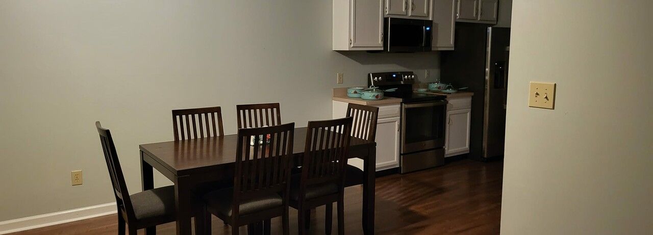 A dining room table and chairs in a kitchen.