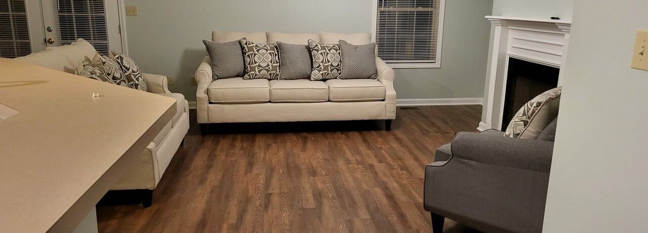 A living room with a couch , chair , and fireplace.