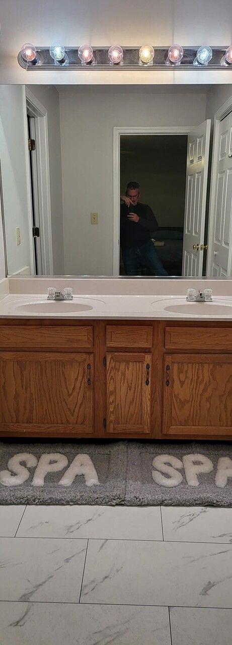 A bathroom with two sinks and a large mirror.