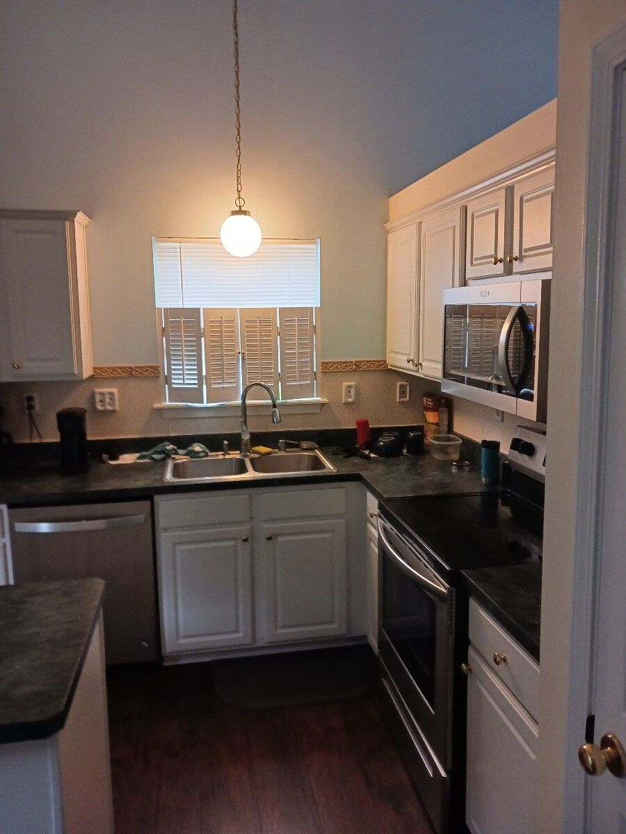 A kitchen with stainless steel appliances and white cabinets
