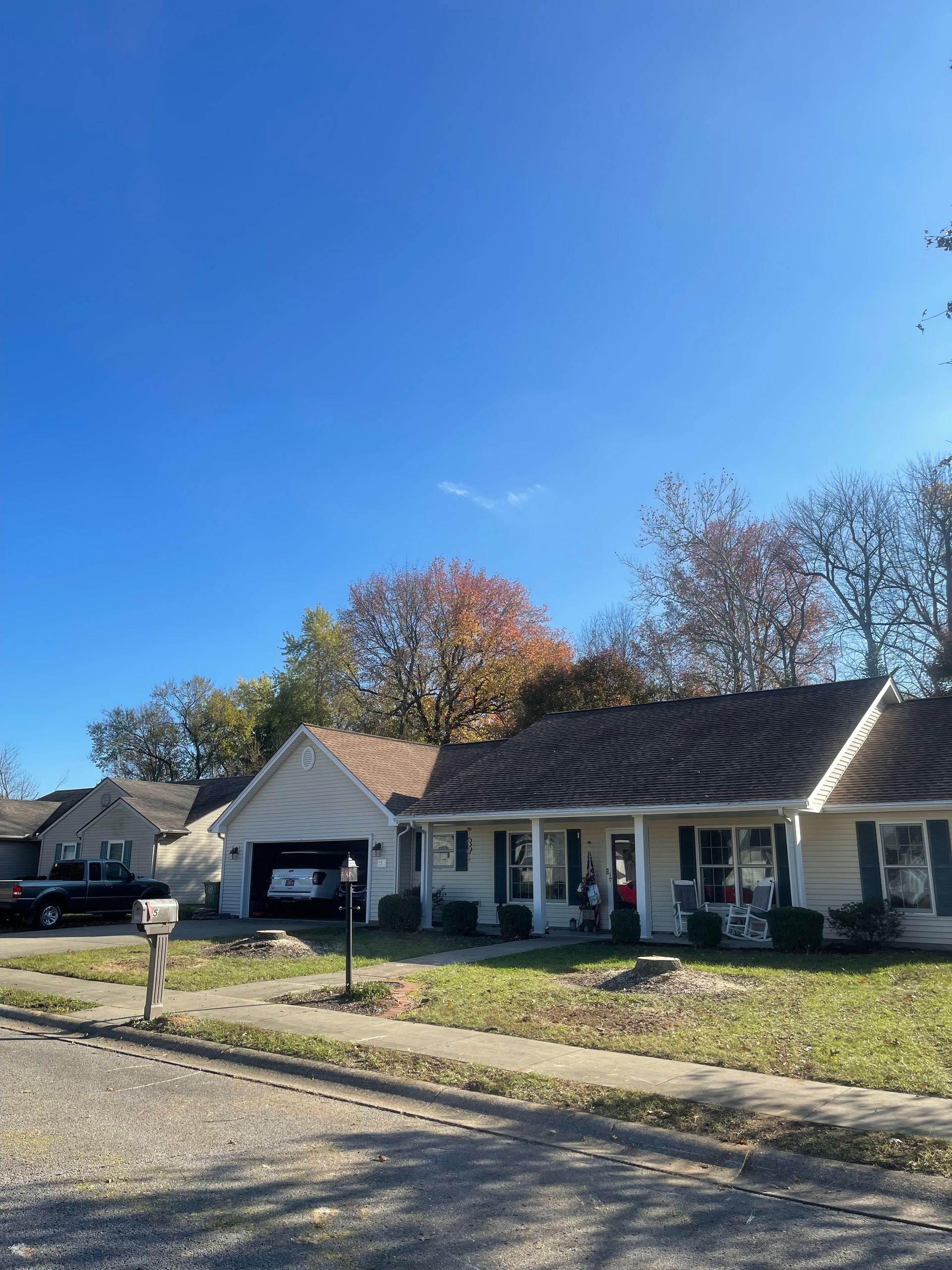 A white house with a brown roof and a mailbox in front of it.