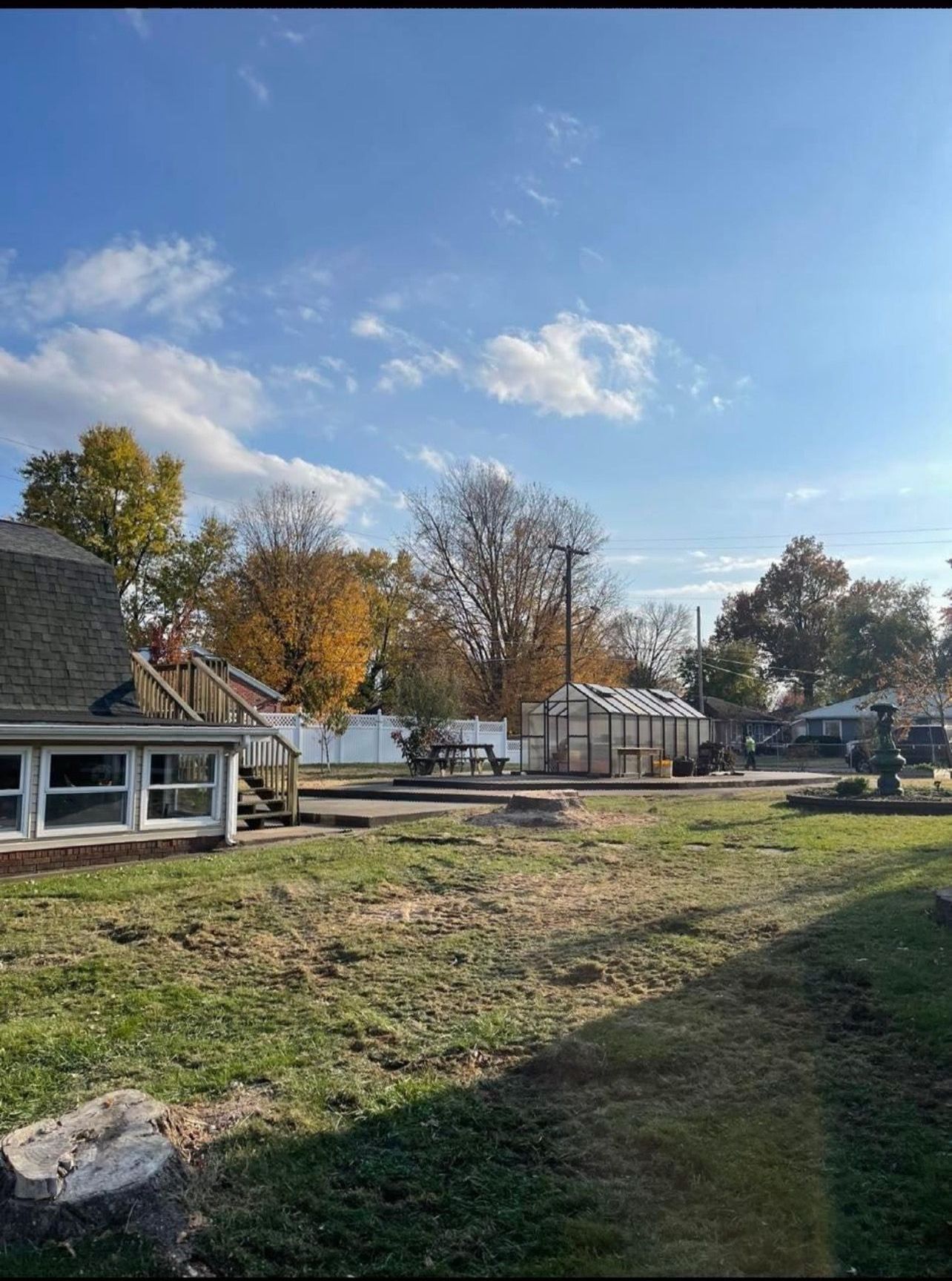 A house is sitting in the middle of a lush green field.