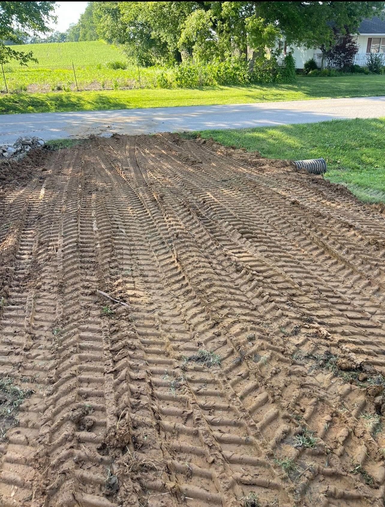 A dirt road with tractor tracks in the dirt.