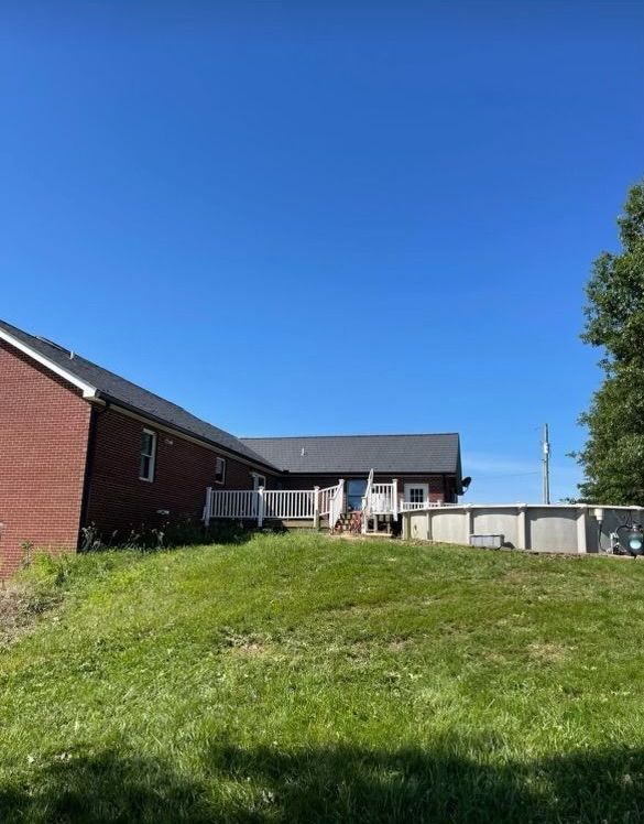 A large brick house with a large lawn in front of it.