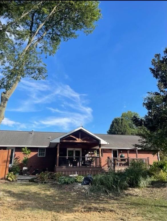 A house with a porch and a blue sky in the background
