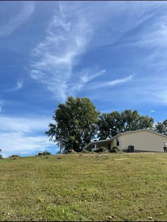 A house sits in the middle of a grassy field